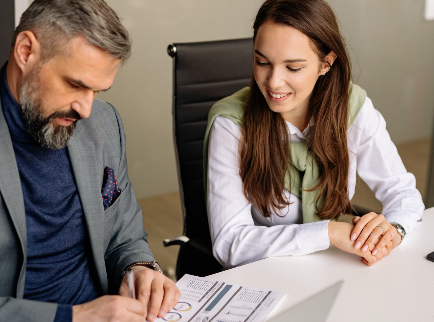 An adviser and a client reviewing a grant application file